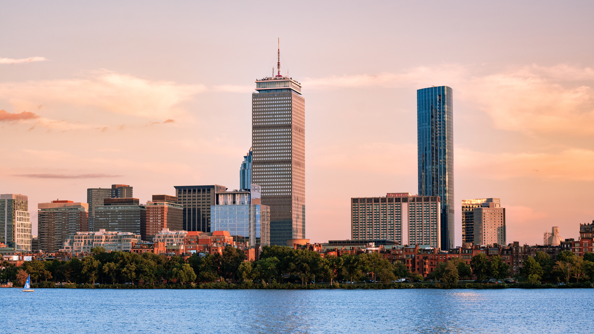 A photo of the Boston skyline featured near the Charles River with the Prudential Center in focus