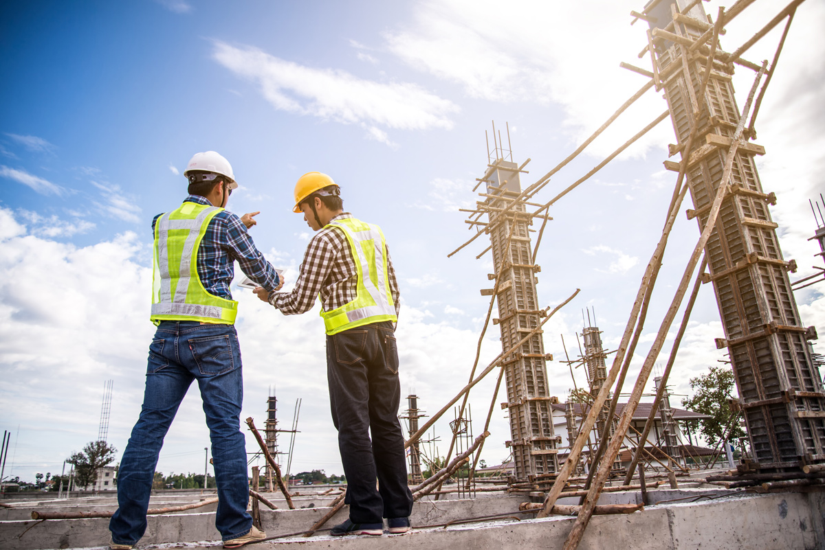 two construction workers looking over plans on a job site