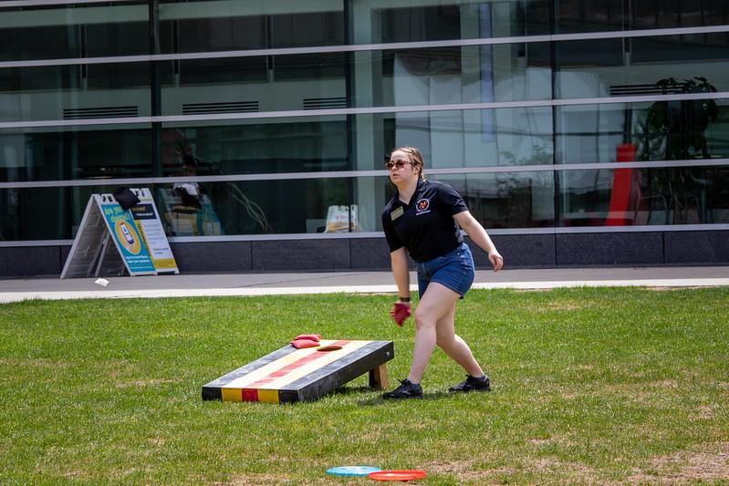 person tossing a bean bag outside