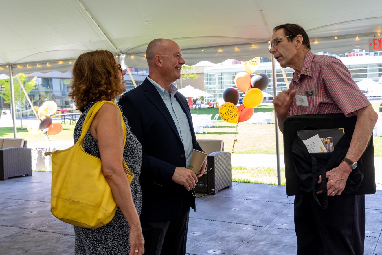 people chatting under a tent