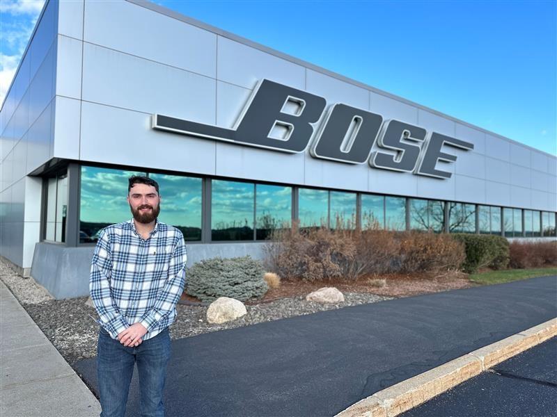 man standing in front of a signing reading bose