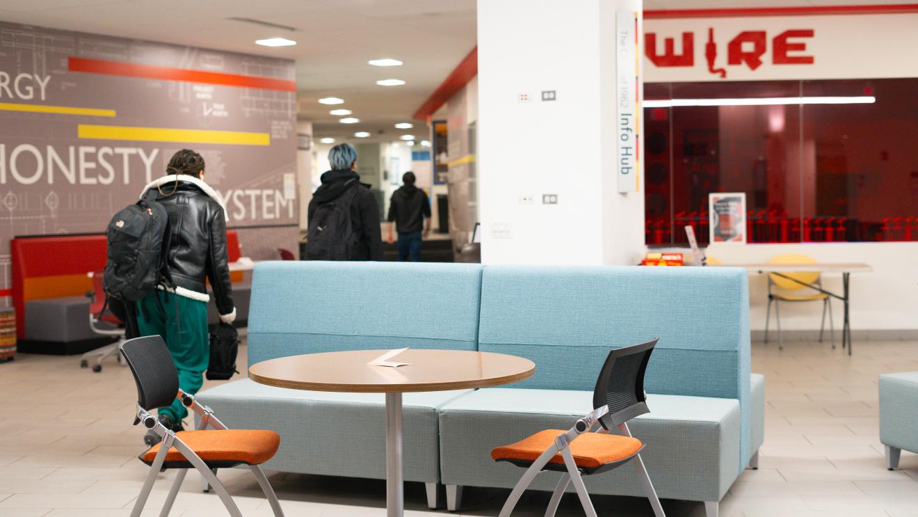 furniture and students walking in a downstairs space