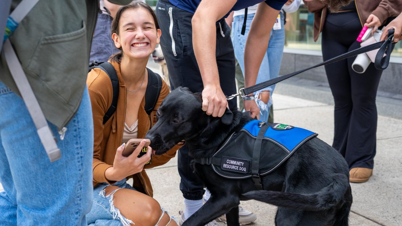 a smiling woman next to a dog