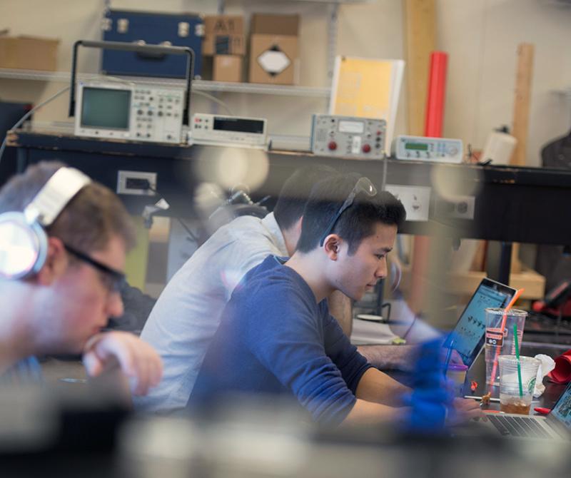 Mechanical engineering students working at laptops.