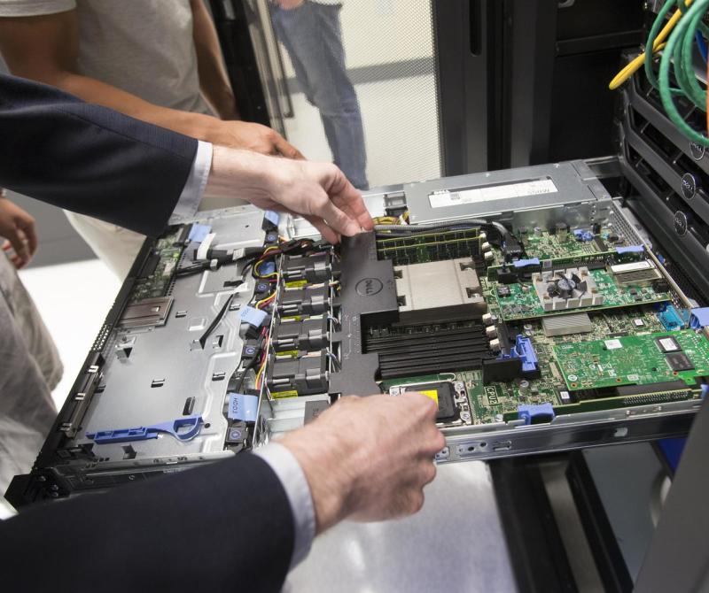 A student pulls a motherboard out from a server