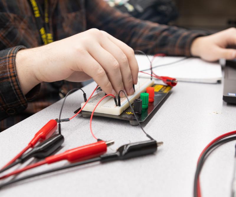 A students tests a circuit board in the lab