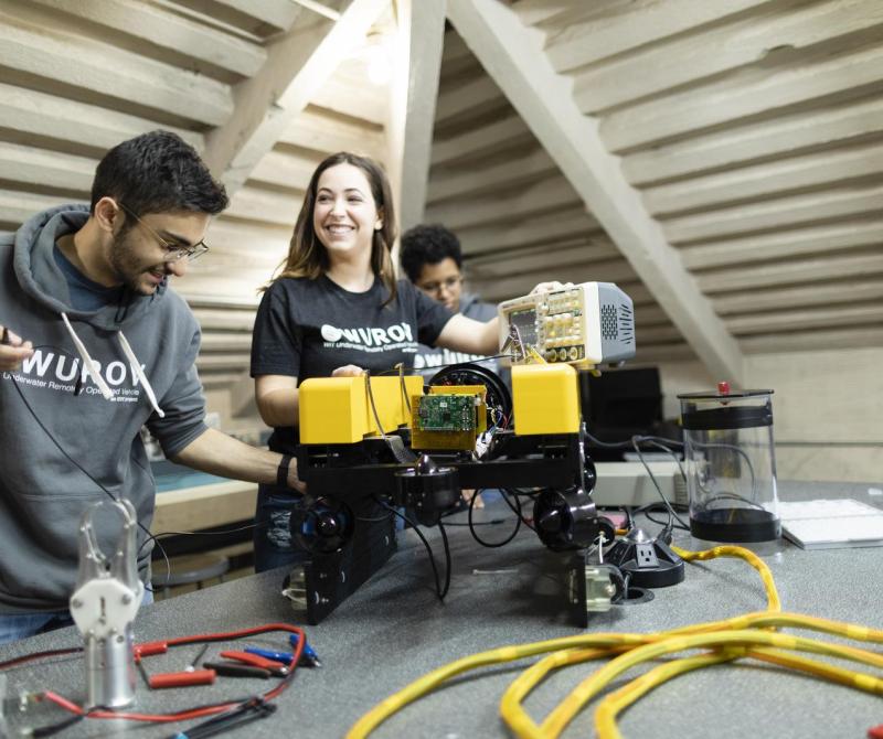 Three students work together on a robotics project