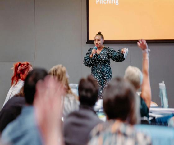 woman speaking to a crowded room