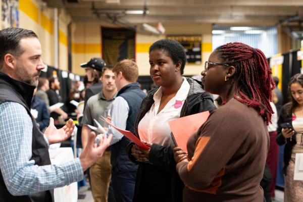 Two women talk with a recruiter at the Co-op & Career Fair.