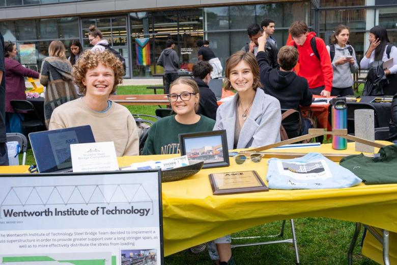 Three students sit at a table for the Student Bridge Club during the student involment fair on the quad.