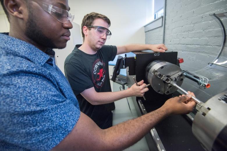 Two male students work in the Strength and Materials lab