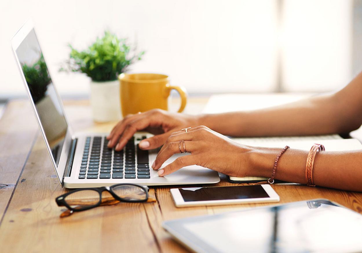 Hands typing on a computer to start job search