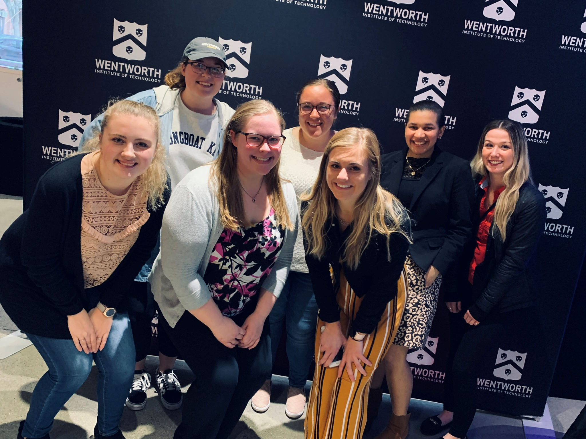 group of woman standing in front of wall