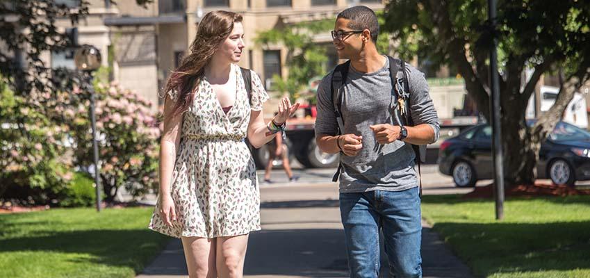 Two students walk across the Wentworth Quad.