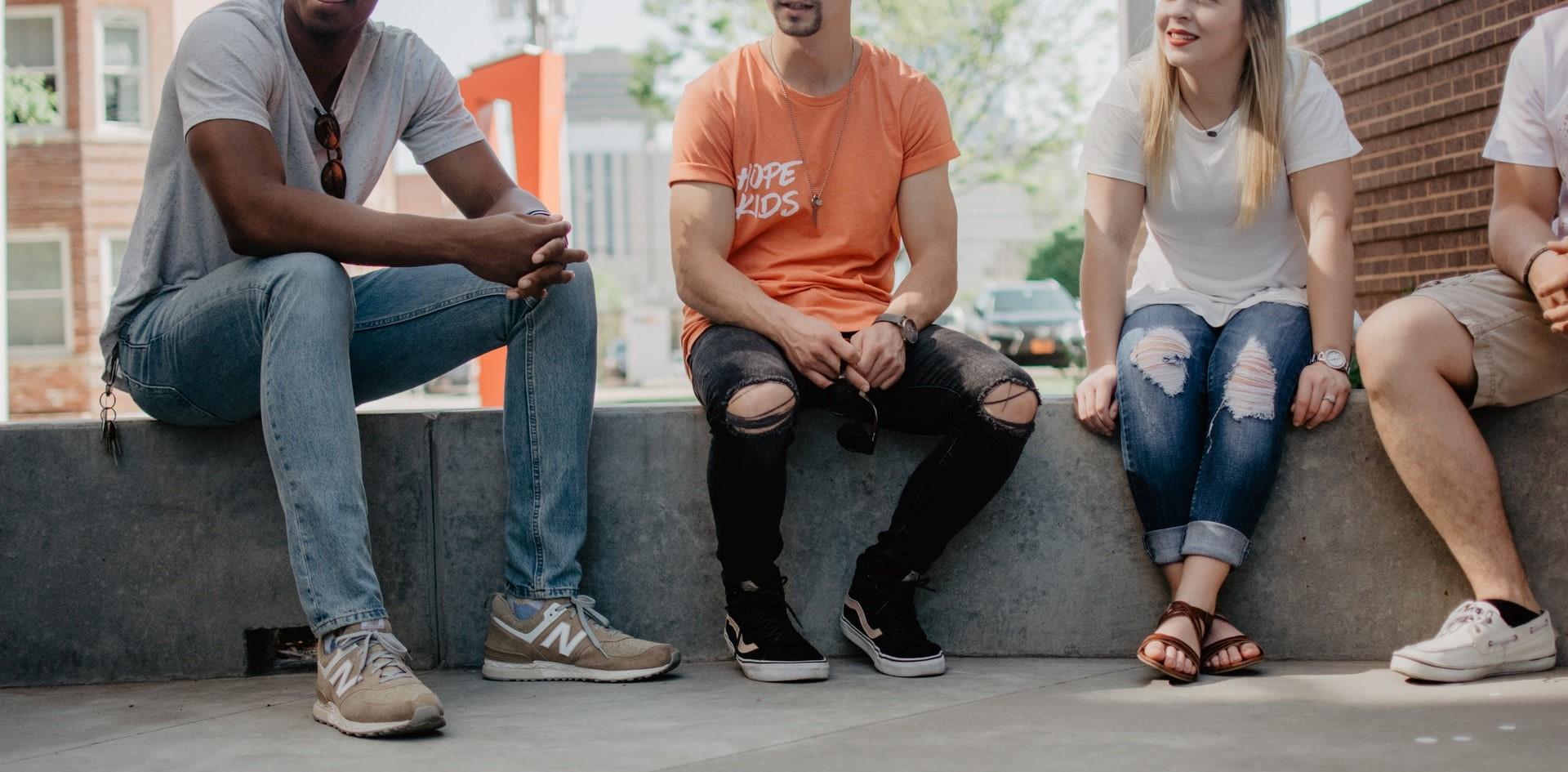 four students sitting in a circle talking