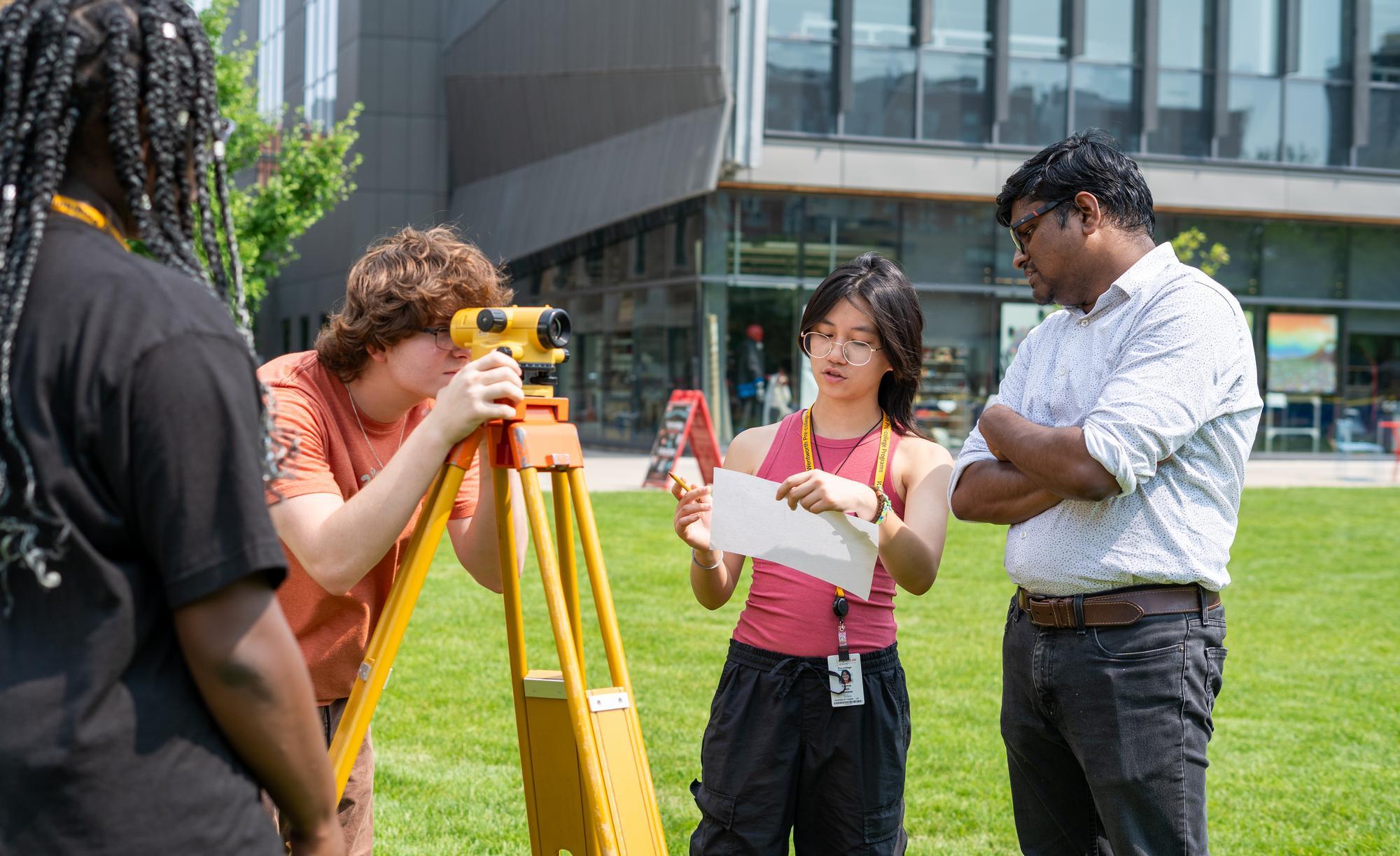 Students use surveying equipment on the quad