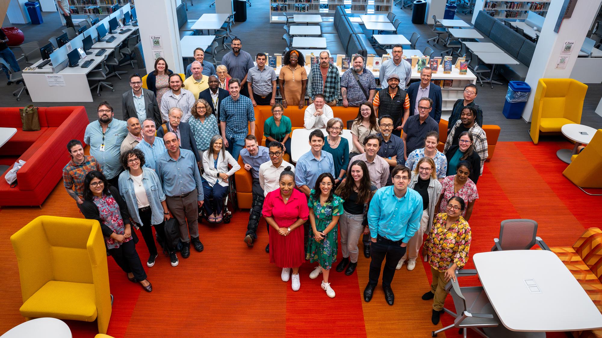 The faculty of the School of Sciences & Humanities gather on the library patio to pose for a photo.