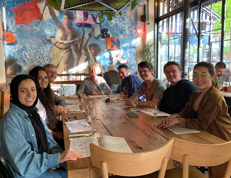 Group of students and faculty on study abroad trip sitting at table