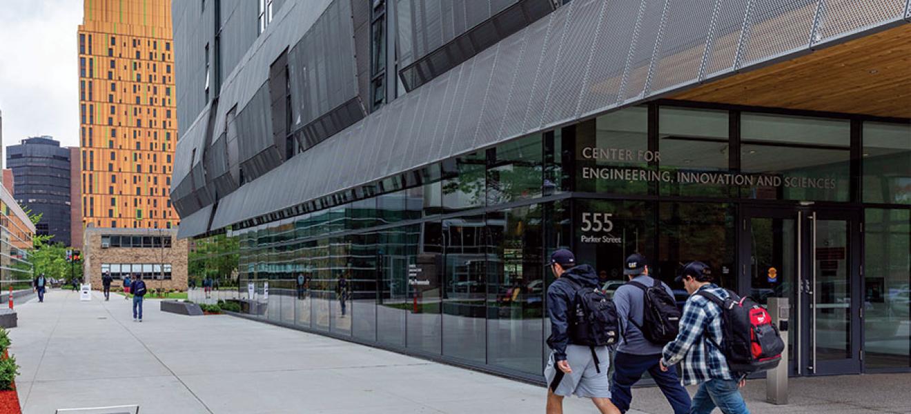 Three students walk past the CEIS building. 