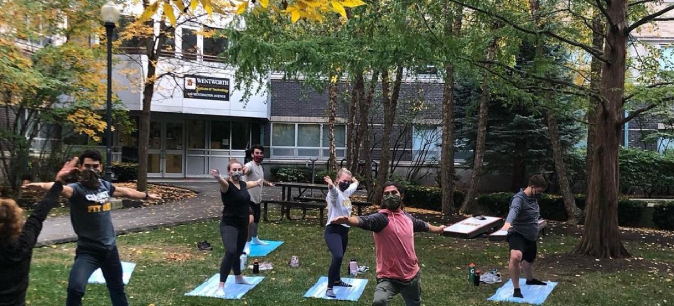 people doing yoga outside while wearing masks