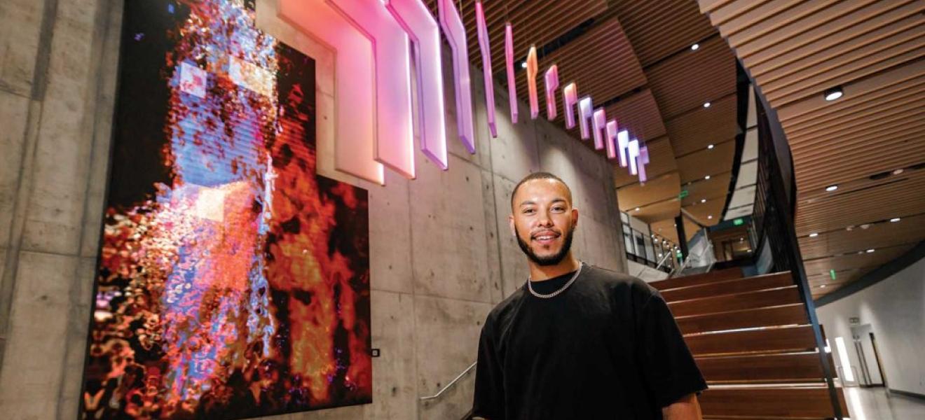 man standing in front of illuminated art installation