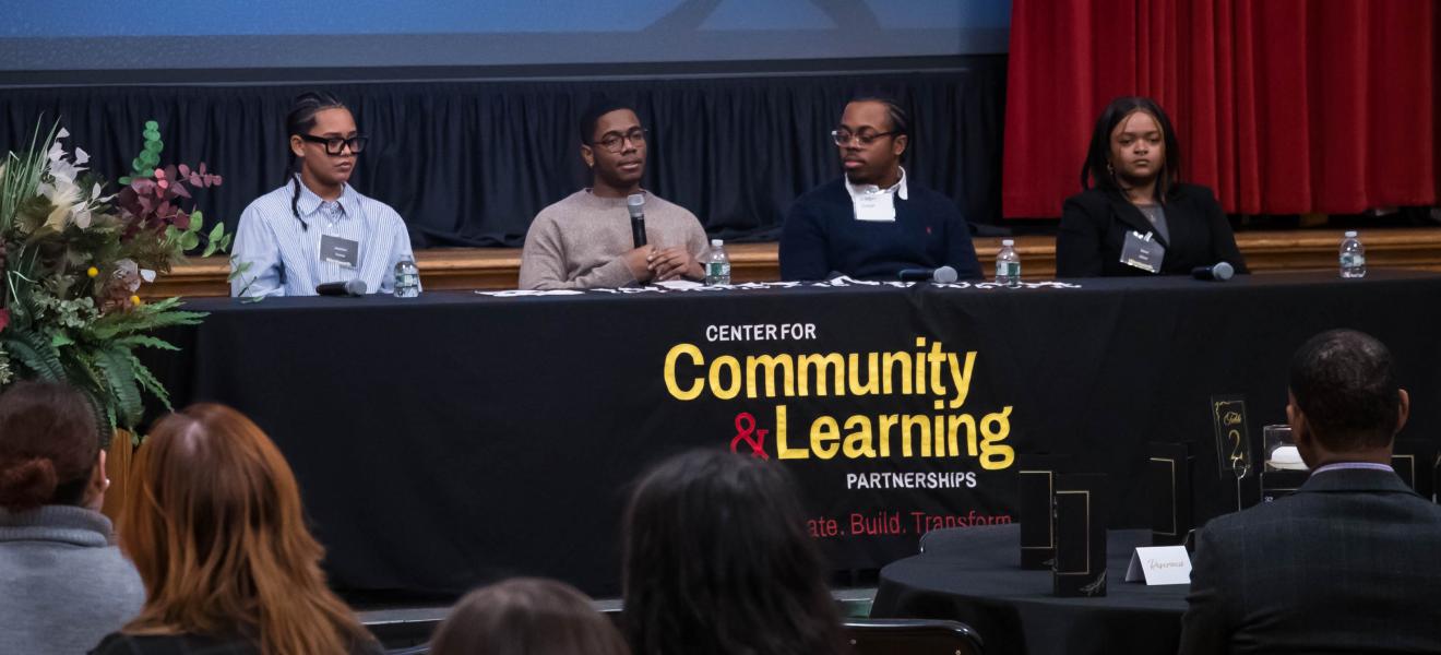 group of people sitting at a table as part of a panel discussion