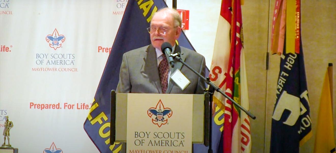 man with glasses speaks at a podium