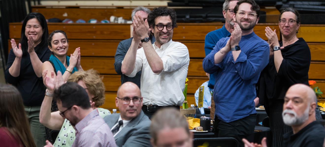 people in a crowd smiling and clapping