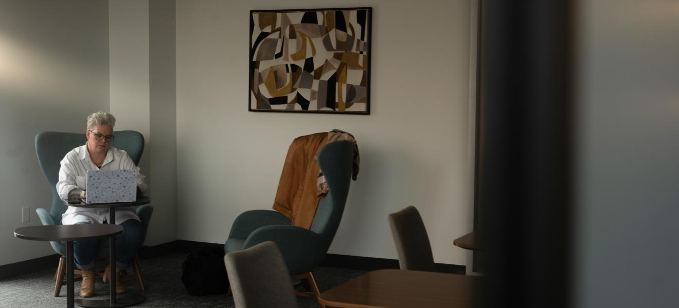 a woman sits at a table with a laptop