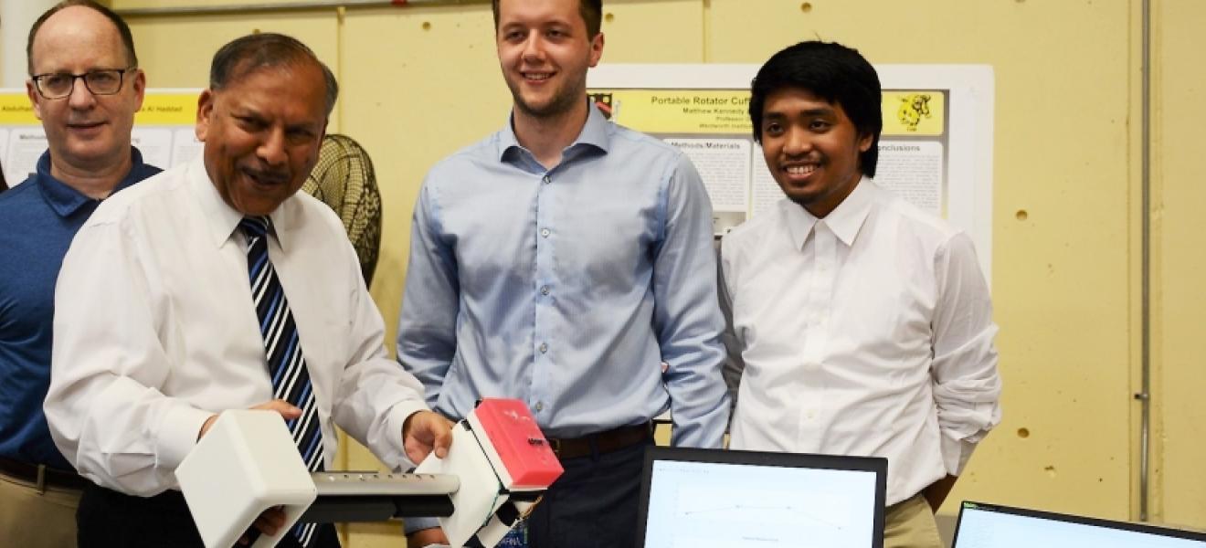 A group of people hold up a portable rotator cuff