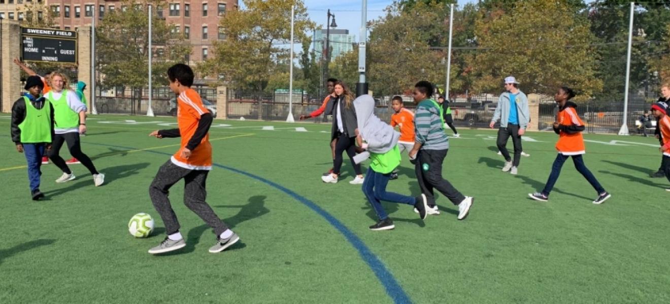 Children playing soccer on an athletic field